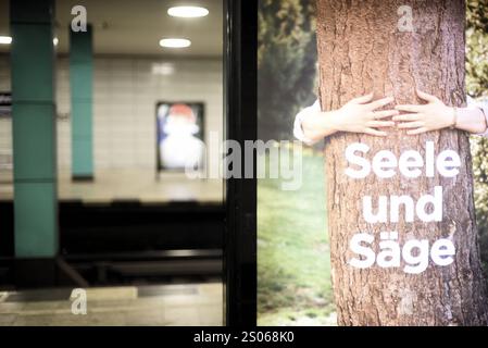 Auf einer Werbetafel am Bahnsteig S-Bahn ist ein Baum zu sehen, der umarmt wird und der Schriftzug Seele und Säge. IMH Hintergrund sind unscharf die benachbarten Bahnsteige zu sehen. Werbung am Bahnsteig Berlin Anhalter Bahnhof *** eine Werbetafel auf dem S-Bahn-Bahnsteig zeigt einen Baum umarmen und die Worte Seele und Säge Soul und Saw im Hintergrund sind die benachbarten Bahnsteige unscharf zu sehen Werbung auf dem Bahnsteig Berlin Anhalter Bahnhof Stockfoto