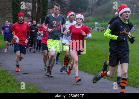 Chippenham, Wiltshire, Großbritannien. Dezember 2024. Die Läufer werden auf dem Bild eines 5 km langen Parklaufs am frühen Weihnachtstag in Monkton Park, Chippenham, abgebildet. Der frühe Start hat den weihnachtsgeist der 300-400 Teilnehmer, die an der Veranstaltung teilnahmen, nicht beeinträchtigt, wobei viele von ihnen sich in schicke Kleidung kleideten. Quelle: Lynchpics/Alamy Live News Stockfoto