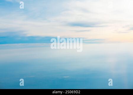 Ein weitläufiger Himmel voller weicher Wolken, aus der Perspektive eines Flugzeugs im Flug erfasst. Luftaufnahme eines klaren blauen Himmels mit flauschiger weißer Wolke Stockfoto