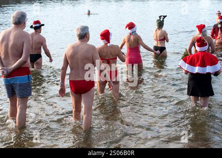 Berlin, Deutschland. Dezember 2024. Mitglieder des Vereins "Berliner Seehunde" gehen zum Weihnachtsschwimmen im Orankesee. Seit über dreißig Jahren kommen die Berliner Robben sonntags von Oktober bis April zum Eisschwimmen in den Orankesee – die Höhepunkte sind das Weihnachtsschwimmen und der Eisschwimmen-Karneval. Quelle: Paul Zinken/dpa/Alamy Live News Stockfoto