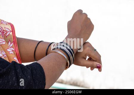 Weibliche Hände mit bunten Glasarmbändern, ein zeitloses Symbol für Schönheit und Eleganz für asiatische Frauen. Stockfoto