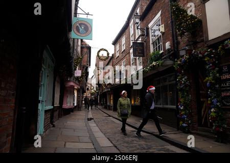 Leute mit Weihnachtshüten auf den Schambles in York. Das Met Office prognostiziert ein „mildes Weihnachten“ mit „besonders hohen Temperaturen“ während der Festtage. Bilddatum: Mittwoch, 25. Dezember 2024. Stockfoto