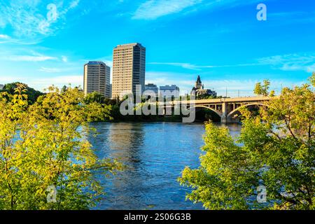 Eine wunderschöne Stadtlandschaft mit einem großen Fluss, der durch sie fließt. Eine Brücke überspannt den Fluss und verbindet die Stadt mit der anderen Seite. Die Stadt ist geschäftig Stockfoto