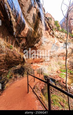 Eine Steinmauer mit einem Geländer und einem Pfad, der hinauf führt. Das Geländer ist aus Metall und der Weg aus Stein. Die Mauer ist sehr hoch und die rai Stockfoto