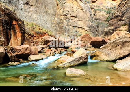 Ein Fluss fließt durch einen felsigen Canyon. Das Wasser ist klar und die Felsen sind groß. Die Szene ist friedlich und ruhig Stockfoto