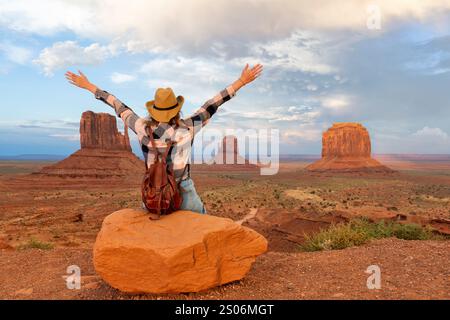 Frau, die im Monument Valley sitzt, mit roten Felsen im Überblick. Arizona Stockfoto