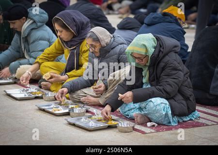 Die Sikh-Tempel verfügen alle über eine langartige Gemeinschaftsküche, in der jeder eine kostenlose vegetarische Mahlzeit erhalten kann. Das ist der Langar im Sikh Cultural Center in Queens NY. Stockfoto