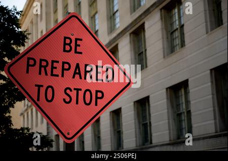 Großes, leuchtend orangefarbenes Schild mit schwarzer Schrift auf einer Stadtstraße Washington D.C., USA. Stockfoto