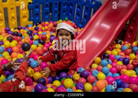 Dhaka, Bangladesch. Dezember 2024. Ein christliches Kind aus Bangladesch spielt in einem Park während einer Veranstaltung zum Weihnachtsfeiertag. Die christliche Gemeinde in Bangladesch feierte Weihnachten mit großer Begeisterung, Festlichkeit und religiösem Eifer. (Foto: Sazzad Hossain/SOPA Images/SIPA USA) Credit: SIPA USA/Alamy Live News Stockfoto