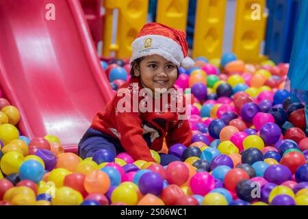 Dhaka, Bangladesch. Dezember 2024. Ein christliches Kind aus Bangladesch spielt in einem Park während einer Veranstaltung zum Weihnachtsfeiertag. Die christliche Gemeinde in Bangladesch feierte Weihnachten mit großer Begeisterung, Festlichkeit und religiösem Eifer. (Foto: Sazzad Hossain/SOPA Images/SIPA USA) Credit: SIPA USA/Alamy Live News Stockfoto