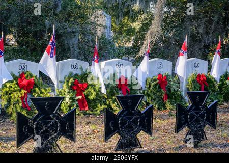 Charleston, Usa. Dezember 2024. Die Grabstätten des ersten erfolgreichen U-Bootes am Denkmal für konföderierte Bürgerkrieg-U-Boote, geschmückt mit Weihnachtskränzen und dem Stainless Banner auf dem Magnolia Cemetery, 22. Dezember 2024 in Charleston, South Carolina. Das handbetriebene U-Boot H.L. Hunley versenkte die USS Housatonic, bevor es 1864 in Charleston Harbor verschwand. Quelle: Richard Ellis/Richard Ellis/Alamy Live News Stockfoto