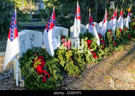 Charleston, Usa. Dezember 2024. Die Grabstätten des ersten erfolgreichen U-Bootes am Denkmal für konföderierte Bürgerkrieg-U-Boote, geschmückt mit Weihnachtskränzen und dem Stainless Banner auf dem Magnolia Cemetery, 22. Dezember 2024 in Charleston, South Carolina. Das handbetriebene U-Boot H.L. Hunley versenkte die USS Housatonic, bevor es 1864 in Charleston Harbor verschwand. Quelle: Richard Ellis/Richard Ellis/Alamy Live News Stockfoto