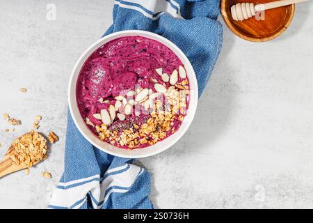 Gesunde Smoothie-Schüssel mit Mandelscheiben und Granola Stockfoto