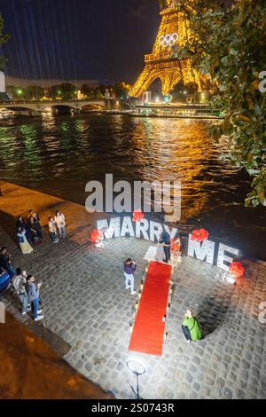 Heiratsantrag und Eiffelturm mit Olympischen Ringen bei Nacht, Paris, Frankreich Stockfoto