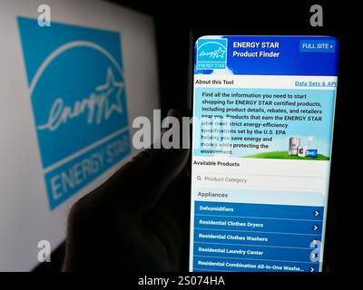 In dieser Abbildung hält eine Person ein Smartphone mit der Webseite des US-Energieeffizienzprogramms Energy Star vor dem Logo. Stockfoto