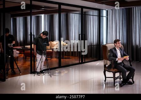 Bangkok, Thailand. Dezember 2024. Kamerateure filmen das Interview hinter dem unabhängigen Journalisten Matt Hunt. Thailands 30. Premierministerin Srettha Thavisin gibt dem unabhängigen Journalisten Matt Hunt drei Monate nach seiner Amtsenthebung auf dem SANSIRI Campus in Bangkok ein Interview. Quelle: Matt Hunt/Neato/Alamy Live News Stockfoto