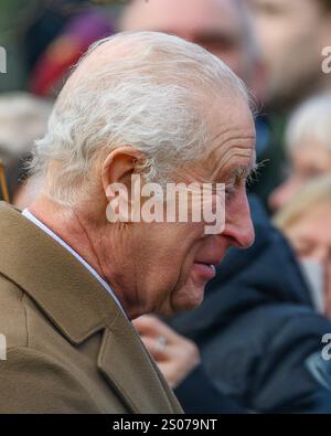 Sandringham, Norfolk, Großbritannien. Dezember 2024. Seine Majestät, König Charles, grüßt wohlwollende Wünsche nach dem Besuch des Weihnachtsgottesdienstes in der St. Mary Magdalene Church auf dem Anwesen Sandringham. Quelle: MartinJPalmer/Alamy Live News Stockfoto