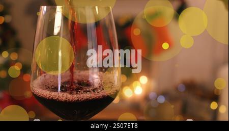 Bild von Punkten, die sich über ein Glas Wein im Zimmer mit weihnachtsdekoration bewegen Stockfoto