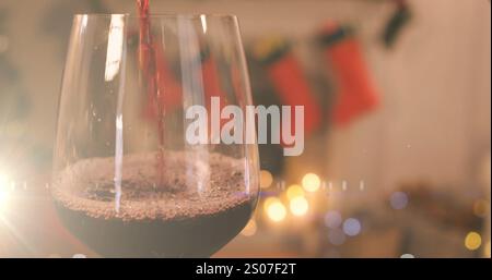 Bild von Rotwein, der über weihnachtsstrümpfen ins Glas gegossen wird Stockfoto