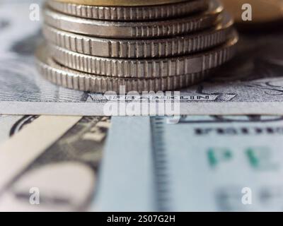Ein Stapel Münzen auf einem Dollarschein. Die Münzen sind Silber und der Dollarschein ist blau Stockfoto