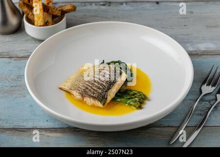 Gegrilltes Seebarschfilet mit Garnierungen in einem eleganten Restaurant Stockfoto