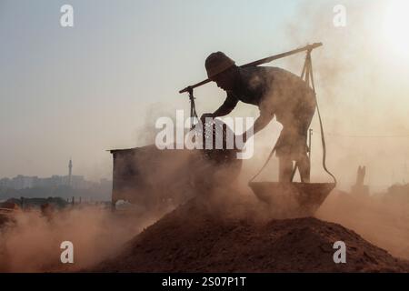 Dhaka, Dhaka, Bangladesch. Dezember 2024. Ein Arbeiter, der in einer Ziegelei in Dhaka, Bangladesch, arbeitet. Jeden Tag wird die Luft durch den schwarzen Rauch verschmutzt, der von den Ziegelfeldern ausgeht. Als Ergebnis der Arbeit auf Ziegelfeldern in einer verschmutzten Umgebung ohne jegliche Schutzausrüstung leiden Ziegelarbeiter an vielen komplexen Krankheiten, einschließlich Atemwegserkrankungen. (Kreditbild: © Abu Sufian Jewel/ZUMA Press Wire) NUR REDAKTIONELLE VERWENDUNG! Nicht für kommerzielle ZWECKE! Quelle: ZUMA Press, Inc./Alamy Live News Stockfoto