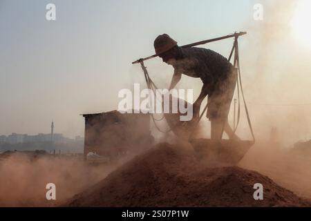 Dhaka, Dhaka, Bangladesch. Dezember 2024. Ein Arbeiter, der in einer Ziegelei in Dhaka, Bangladesch, arbeitet. Jeden Tag wird die Luft durch den schwarzen Rauch verschmutzt, der von den Ziegelfeldern ausgeht. Als Ergebnis der Arbeit auf Ziegelfeldern in einer verschmutzten Umgebung ohne jegliche Schutzausrüstung leiden Ziegelarbeiter an vielen komplexen Krankheiten, einschließlich Atemwegserkrankungen. (Kreditbild: © Abu Sufian Jewel/ZUMA Press Wire) NUR REDAKTIONELLE VERWENDUNG! Nicht für kommerzielle ZWECKE! Quelle: ZUMA Press, Inc./Alamy Live News Stockfoto