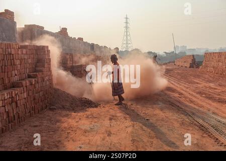 Dhaka, Dhaka, Bangladesch. Dezember 2024. Ein Arbeiter, der in einer Ziegelei in Dhaka, Bangladesch, arbeitet. Jeden Tag wird die Luft durch den schwarzen Rauch verschmutzt, der von den Ziegelfeldern ausgeht. Als Ergebnis der Arbeit auf Ziegelfeldern in einer verschmutzten Umgebung ohne jegliche Schutzausrüstung leiden Ziegelarbeiter an vielen komplexen Krankheiten, einschließlich Atemwegserkrankungen. (Kreditbild: © Abu Sufian Jewel/ZUMA Press Wire) NUR REDAKTIONELLE VERWENDUNG! Nicht für kommerzielle ZWECKE! Quelle: ZUMA Press, Inc./Alamy Live News Stockfoto