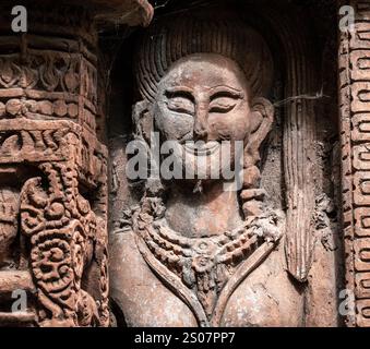 Statue einer Frau mit Halskette. Die Statue ist aus Stein. Die Frau lächelt Stockfoto