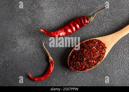 Rote Chilischoten. Rote Chilischoten in einer Holzschale auf grauem Hintergrund. Getrocknete Chilischoten Stockfoto