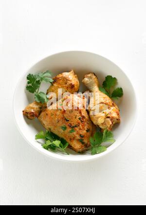 Im Ofen gebackenes Hühnerfleisch mit Kräutern in der Schüssel auf weißem Hintergrund. Leckeres gesundes Essen zum Abendessen. Nahansicht Stockfoto
