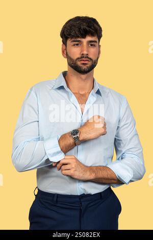 Selbstbewusster Geschäftsmann, der seine Hemdärmel hochkrempelt, bereit für Action Stockfoto