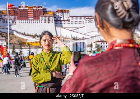 Peking, Chinas autonome Region Xizang. Februar 2024. Ein Tourist posiert für Fotos vor dem Potala-Palast in Lhasa, südwestchinesischer Autonomen Region Xizang, 11. Februar 2024. Quelle: Sun Fei/Xinhua/Alamy Live News Stockfoto