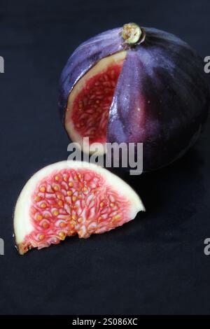 Geschnittene Feige mit roten Seeds auf dunklem Hintergrund Stockfoto
