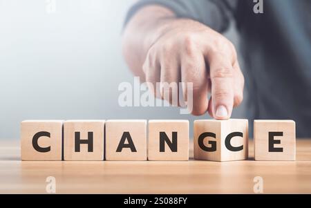 Ein Mann wählt zwischen den Wörtern „VERÄNDERUNG“ und „CHANCE“ auf Holzblöcken, symbolisiert den Entscheidungsprozess und nimmt Wachstumschancen auf Stockfoto
