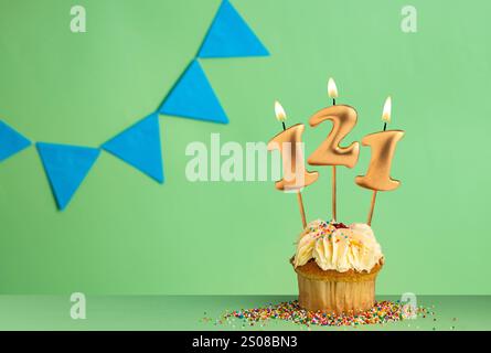 Geburtstagskarte mit der Zahl 121 Kerze - Cupcake auf grünem Hintergrund mit blauen Wimpeln. Stockfoto