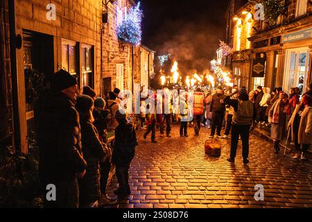 Haworth, West Yorkshire, Vereinigtes Königreich: Im Dezember findet jedes Jahr eine Fackelprozession statt. Flsming-Fackeln werden auf der steilen Main Street in Haworth Whi getragen Stockfoto