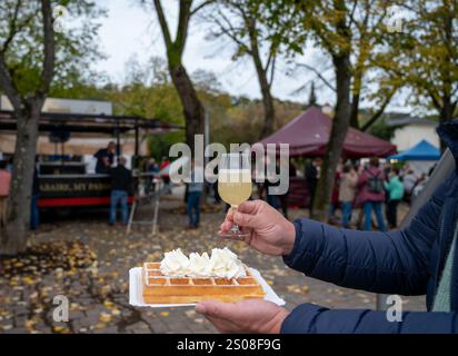 Weinfest in Schengen, Luxemburg, französischen oder luxemburgischen Waffeln mit Schlagsahne und einem Glas Jungwein, der im Herbst im Freien gegessen wird Stockfoto