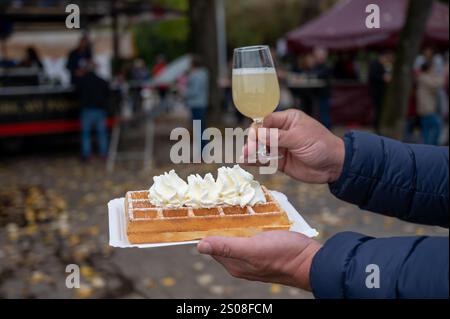 Weinfest in Schengen, Luxemburg, französischen oder luxemburgischen Waffeln mit Schlagsahne und einem Glas Jungwein, der im Herbst im Freien gegessen wird Stockfoto