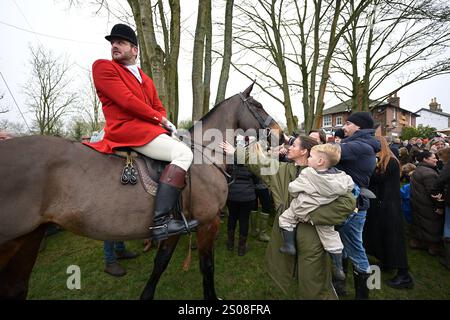 Essex mit Farmern und Union Hunt Hunderte von Menschen nehmen Teil, als sich das Essex mit Farmern und Union Hunt zu seiner jährlichen Fahrt am zweiten Weihnachtsfeiertag vom Chequers Pub im ländlichen Essex-Dorf Matching Green UK aufmacht. Die Essex Hunt trifft sich seit dem frühen 19. Jahrhundert regelmäßig in Matching Green, obwohl es seit dem Jagdgesetz von 2004 nicht erlaubt ist, Hunde zum Jagen und Töten von Füchsen zu verwenden. Matching Green Essex UK Copyright: XMartinxDaltonx Essex Hunt261224 MD 581 Stockfoto