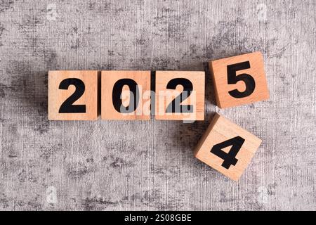 2025 Happy New Year. Holzwürfelblock Wechsel von 2024 auf 2025. Konzept 2025 Hintergrund zum Neujahr Stockfoto