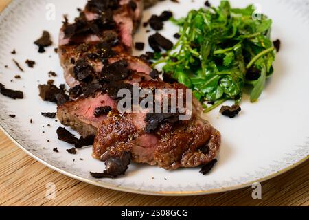 Tagliata di Manzo al Tartufo Rindersteak mit Trüffeln serviert mit grünem Rocket- oder Arugula-Salat Stockfoto