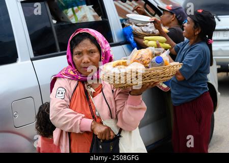 Redjang, Flores, Indonesien - 1. November 2024: Straßenverkäufer verkaufen Snacks an wartende Autos. Stockfoto