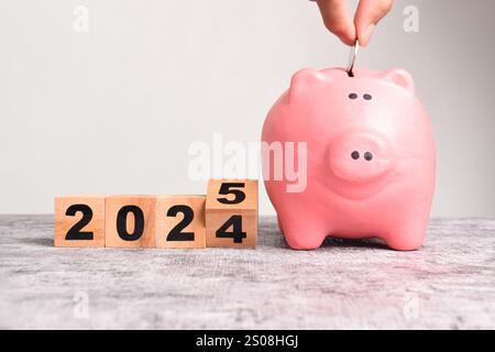 2025 Happy New Year. Holzwürfelwechsel von 2024 bis 2025 mit Schweinebank. Lösung, Ziele, Plan, Aktion, Geldeinsparungen, Pensionskasse, Pensi Stockfoto