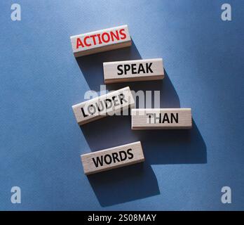 Taten sprechen lauter als Wörter. Holzblöcke mit Worten Aktionen sprechen lauter als Worte. Schöner grauer Hintergrund. Business and Actions conc Stockfoto