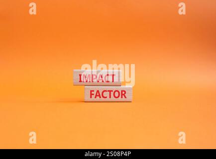 Symbol für Aufprallfaktor. Holzblöcke mit den Worten Impact Factor. Wunderschöner orangefarbener Hintergrund. Business and Impact Factor Konzept. Kopierbereich. Stockfoto