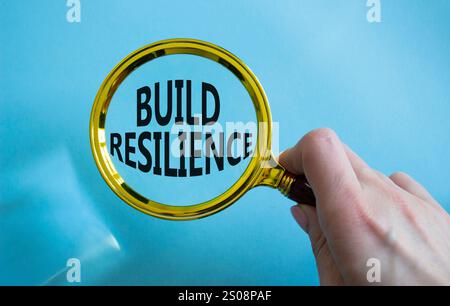 Symbol für Belastbarkeit erstellen. Holzklötze mit Wörtern sorgen für Widerstandsfähigkeit. Wunderschöner blauer Hintergrund. Geschäftsmann Hand. Business- und Build Resilience-Konzept Stockfoto