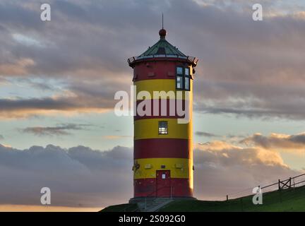 Der Pilsum Leuchtturm ist ein Leuchtturm am Nordseedeich. Der Leuchtturm ist eines der berühmtesten Wahrzeichen in Ostfriesland. Stockfoto