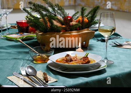 Traditioneller slowakischer weihnachtstisch mit Kohleintopf, Weißwein, Honig und festlicher Dekoration. Stockfoto