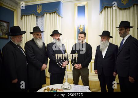 Kiew, Ukraine. Dezember 2024. Der ukrainische Präsident Wolodymyr Zelenskyj, Mitte, schließt sich den Rabbinern an einer Zeremonie zur Kerzenbeleuchtung am ersten Tag des Hanukka-Feiertags im Mariinskyi-Palast am 25. Dezember 2024 in Kiew, Ukraine. Kredit: Ukrainischer Ratsvorsitz/Pressestelle Des Ukrainischen Präsidenten/Alamy Live News Stockfoto